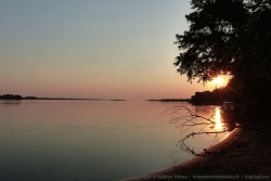 Les derniers rayons du soleil couchant embrasent le lit du fleuve