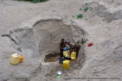 Les femmes du village viennent prendre l'eau dans ce trou creusé dans le sable