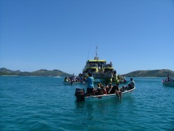 Flotille de barques autour du grand catamaran de liaison inter-îles car souvent il n'y a pas de ports pour débarquer
